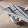 A hand is placing a clear phone case with a phone inside onto a wireless charger. Produktbild-Vorschau