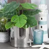 A silver cylindrical pot with a green plant and decorative items on a shelf. Produktbild-Vorschau