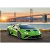 A bright green Lamborghini sports car is parked on a paved surface with a large suspension bridge and city skyline in the background during sunset. Náhľad obrázku produktu