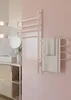 A modern bathroom with a pink tiled wall, a vanity with a sink, and a chrome towel warmer with towels hanging on it. Podgląd zdjęcia produktu
