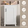 A white bathroom cabinet with a dark handle, placed in a bathroom setting with a mirror and a small bouquet of flowers. Náhled obrázku produktu
