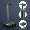 A gaming headset stand with RGB lighting and a wireless charger, shown with close-up feature callouts. Podgląd zdjęcia produktu
