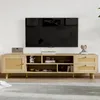 A wooden TV stand with rattan accents is shown in a living room setting, with a television mounted on the wall above it. Produktbild-Vorschau