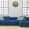 A modern living room with a blue sectional sofa, decorative pillows, and a wooden wall clock. Náhled obrázku produktu