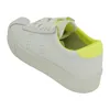 A single white sneaker with yellow accents is shown from a side angle against a white background. Produktbild-Vorschau