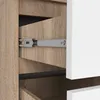 A close-up view of an open drawer in a wardrobe, showing the drawer slide mechanism and the wood-grain texture of the drawer and wardrobe. Produktbild-Vorschau
