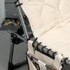 Close-up of a folding lounge chair with a side pocket holding magazines. Produktbild-Vorschau