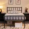 A bedroom scene with a metal bed frame, nightstands, and artwork on the wall. Podgląd zdjęcia produktu