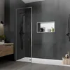 A modern bathroom with a walk-in shower, vanity, and recessed shelf. Náhled obrázku produktu