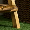 A close-up view of a wooden plant stand leg on artificial grass, with a woven basket in the background. Produktbild-Vorschau