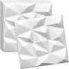 A stack of white 3D wall panels with a geometric design, with one panel placed in front of the stack.