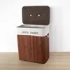 A laundry basket with two compartments, made of bamboo, with a brown lid. Produktbild-Vorschau