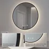 A round LED mirror with a black frame, illuminated from behind, mounted on a light gray wall. Insets show close-ups of the frame and the backlighting. Voir les images du produit