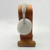 A pair of silver headphones is displayed on a wooden stand against a white background. Produktbild-Vorschau