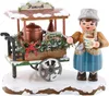 A wooden figurine of a woman serving punch from a cart. Produktbild-Vorschau