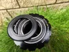 A close-up shot of bicycle bottom bracket parts resting on grass with a brick wall in the background. Voir les images du produit