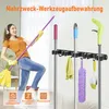 A woman is happily cleaning with a mop, with a wall-mounted organizer holding several cleaning tools in the background. Náhled obrázku produktu