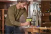 A man is using a Ryobi router in a workshop. Wood dust is visible in the air. Anteprima dell’immagine prodotto