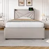 A beige upholstered bed with a geometric headboard is shown in a bedroom setting. Produktbild-Vorschau
