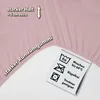 Close-up of a pink fabric with text and care symbols. Produktbild-Vorschau