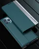 A teal and silver flip case for an iPhone is shown from a diagonal angle, with the phone partially visible underneath. Produktbild-Vorschau