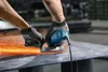 A person wearing gloves is using a blue angle grinder to cut metal, creating a shower of sparks. Produktbild-Vorschau