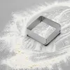 A square metal cookie cutter is placed on a surface dusted with flour. Anteprima dell’immagine prodotto