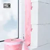 A roll of pink insulation tape is shown next to a window frame and white building blocks, suggesting its use in construction or renovation. Produktbild-Vorschau