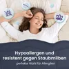 A woman is sleeping comfortably in bed, with icons representing hypoallergenic and dust mite resistance floating around her. Produktbild-Vorschau