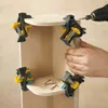 A person is using corner clamps to assemble a wooden shelf unit, with a drill and screws visible. Produktbild-Vorschau