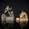 Two Tomb Raider statues of Lara Croft are displayed against a black background, with their reflections visible below. Anteprima dell’immagine prodotto