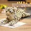 A plush toy leopard lying on a wooden surface with a blurred background. Náhled obrázku produktu