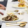 A table setting with a plate of food and gold cutlery. Anteprima dell’immagine prodotto