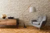 A modern living room scene with a floor lamp, armchair, and cabinet against a textured wall and wood floor. Podgląd zdjęcia produktu