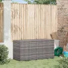 A grey rattan storage box sits on a green lawn in front of a wooden fence. Podgląd zdjęcia produktu