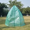 A green geodesic dome greenhouse sits on a grassy lawn with trees and a building in the background. Produktbild-Vorschau