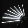 A fan of white LED meteor shower lights arranged on a dark, textured surface. Produktbild-Vorschau