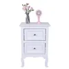 A white nightstand with two drawers, decorated with a vase of pink flowers and a small pink fan. Produktbild-Vorschau