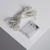 A close-up shot of a string of LED lights and a battery pack on a white surface. Produktbild-Vorschau