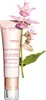 A tube of Clarins Calm-Essentiel Repairing Soothing Balm is shown next to a sprig of pink flowers. Anteprima dell’immagine prodotto