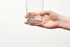 A hand holding a clear glass. Náhľad obrázku produktu
