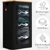 A black laundry basket with a wooden top, filled with folded clothes. It has a mesh window showing the clothes inside and graphic overlays indicating features. Produktbild-Vorschau