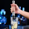 A hand is holding a cocktail muddler and pressing it into a glass with lemon slices. Produktbild-Vorschau