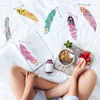 A person is sitting on a bed with an open book and a bowl of granola and strawberries. Produktbild-Vorschau