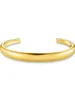 A plain studio shot of a gold cuff bracelet. Anteprima dell’immagine prodotto