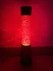 A red lava lamp is lit up against a red background. Anteprima dell’immagine prodotto