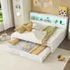 A white daybed with a pull-out trundle bed, decorated with pillows and blankets, in a bedroom setting with a window and wall decorations. Náhled obrázku produktu