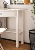 A close-up view of a white desk with a drawer and a shelf, showing a pen holder and books. Anteprima dell’immagine prodotto