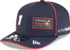 A close-up view of a navy blue baseball cap with red trim and various logos and text. Anteprima dell’immagine prodotto