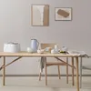 A dining table set for breakfast with a coffee pot, bowls, and a newspaper. Produktbild-Vorschau